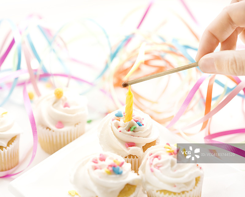 迷你纸杯蛋糕上的照明蜡烛图片素材