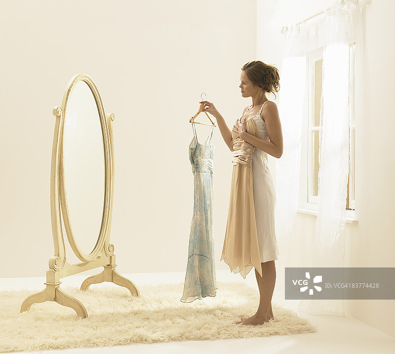 年轻女子试穿连衣裙图片素材