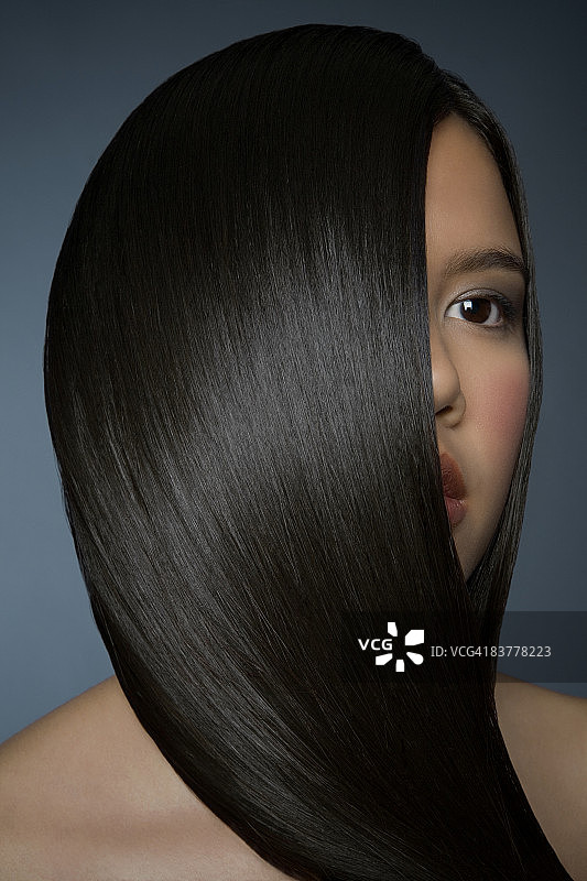 拥有光滑亮丽头发遮住脸庞的女人图片素材