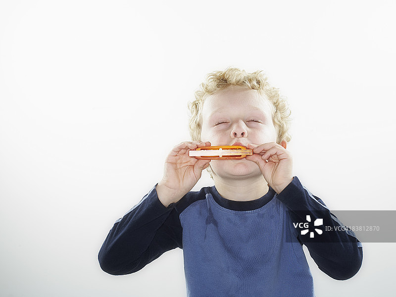 男孩演奏口琴图片素材