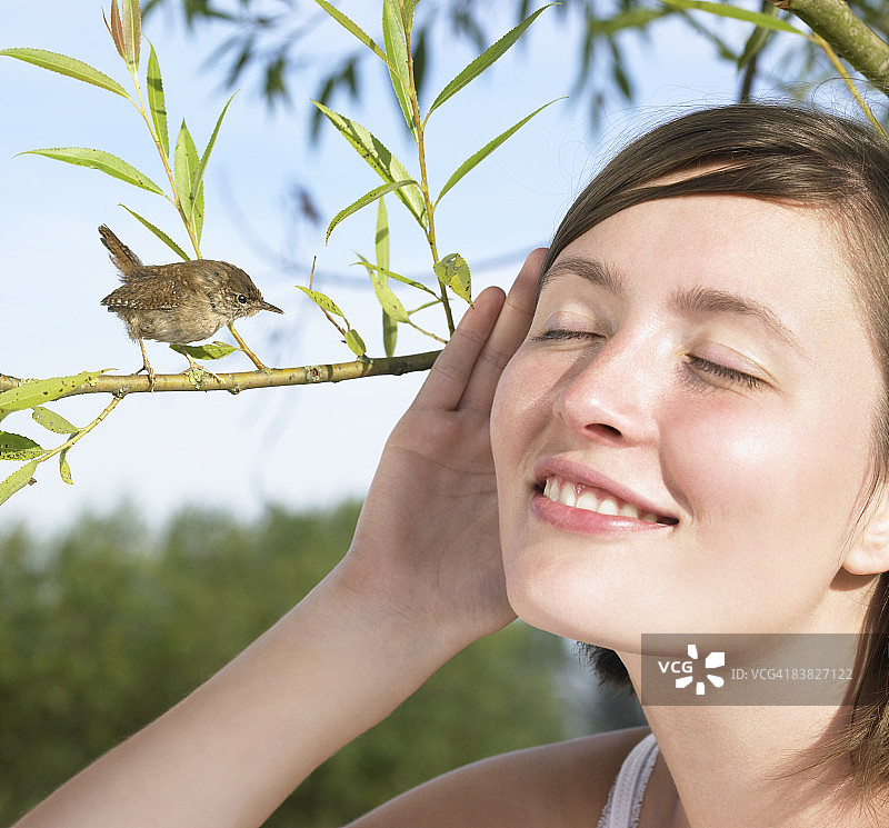 年轻女人在听小鸟叫图片素材