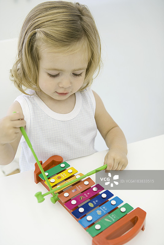 高角度拍摄：玩木琴的幼儿女孩图片素材