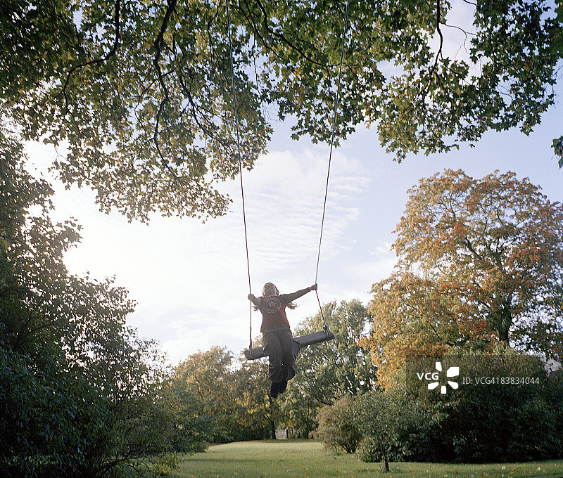 荡秋千的年轻女孩图片素材