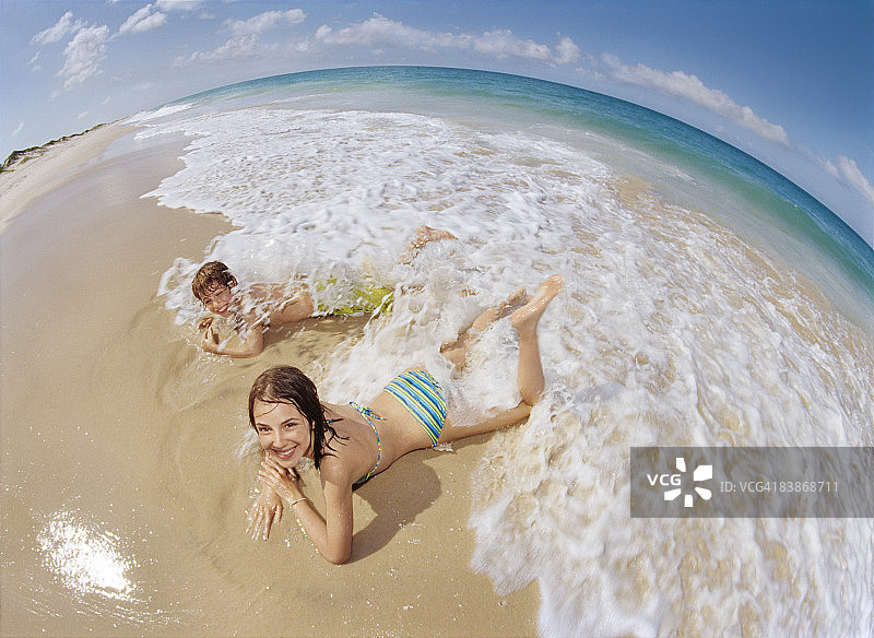 小兄妹在沙滩海浪中玩耍图片素材