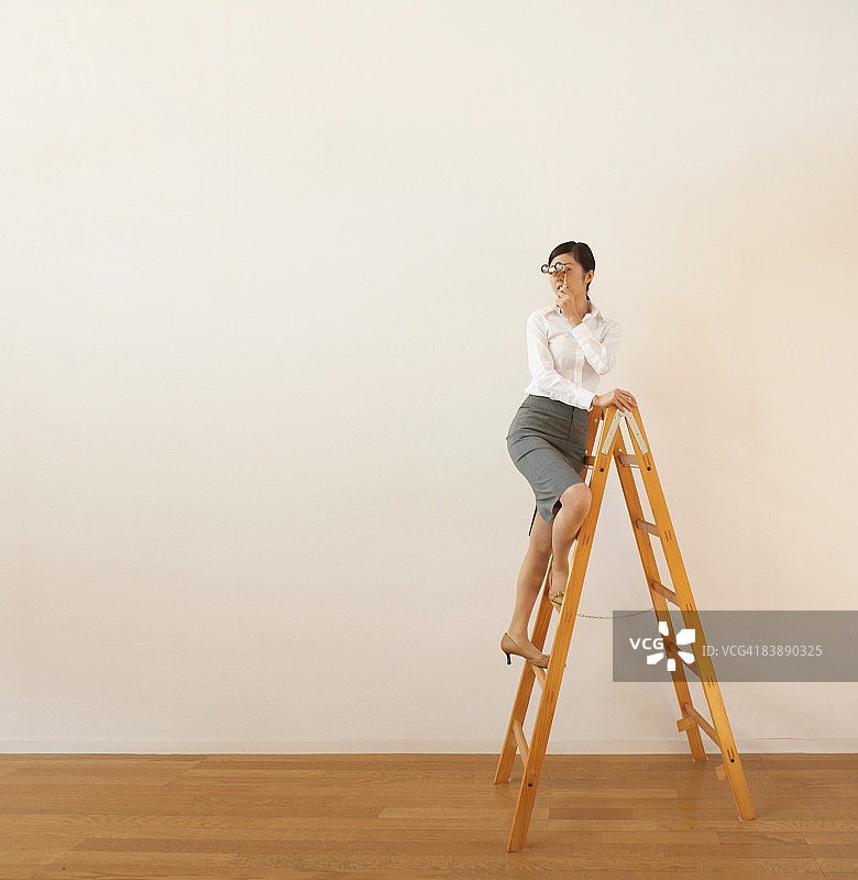 女商人梯子上拿望远镜图片素材