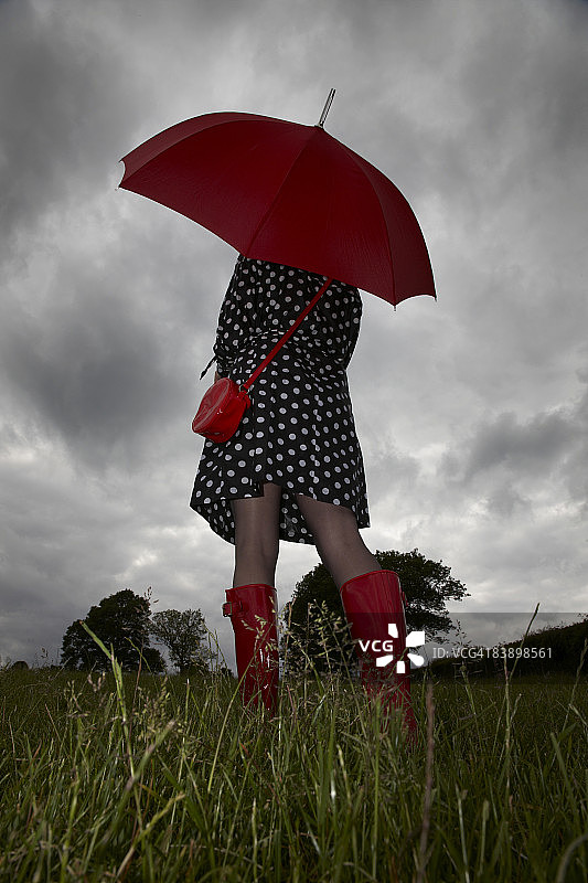 在暴风雨中撑伞行走的女人图片素材
