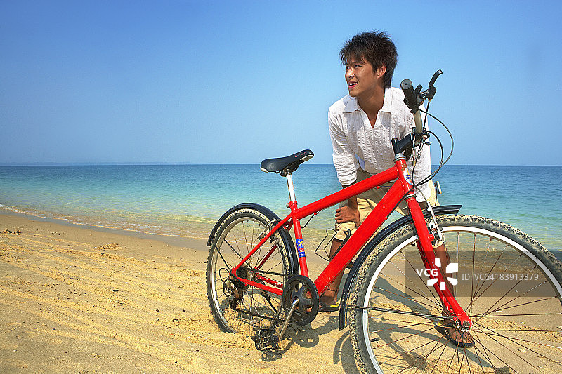 在海滩上骑自行车的男人图片素材