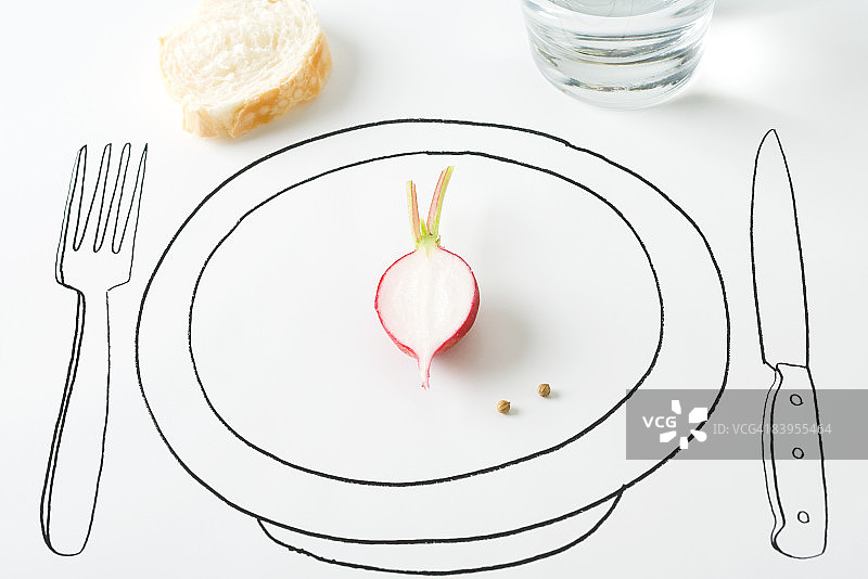 盘子上的半个萝卜和两个胡椒粒，附近有面包图片素材