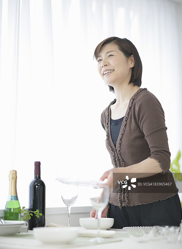 中年妇女摆放餐桌图片素材