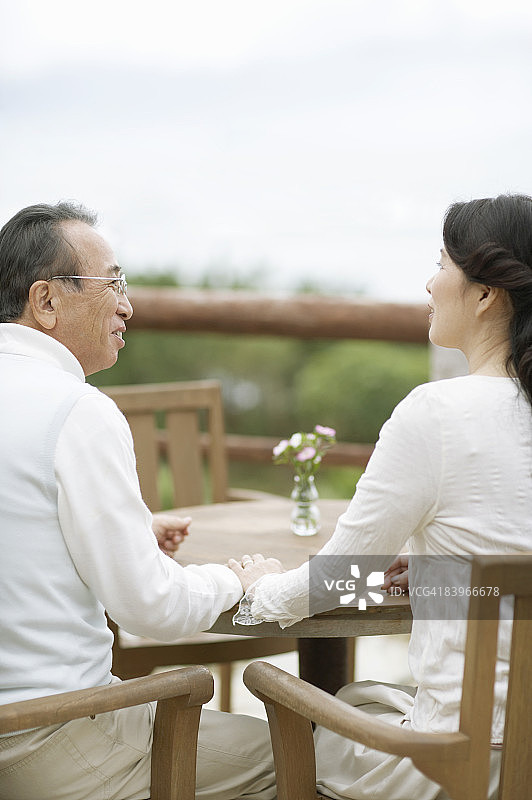 老年夫妇在桌子上牵手图片素材