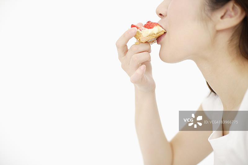 女子在影棚里吃草莓派图片素材