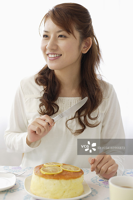 女人切割柠檬海绵蛋糕图片素材