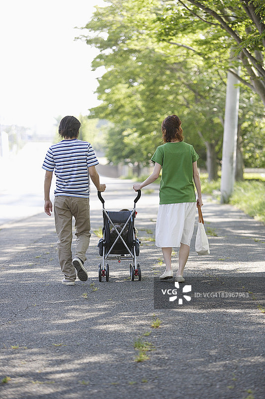 情侣推着婴儿车散步（后视图）图片素材