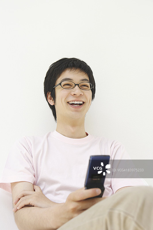 男人使用手机，面带微笑图片素材