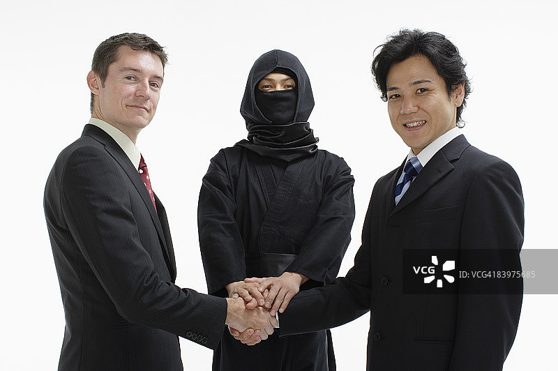 忍者与商人握手，影棚拍摄图片素材