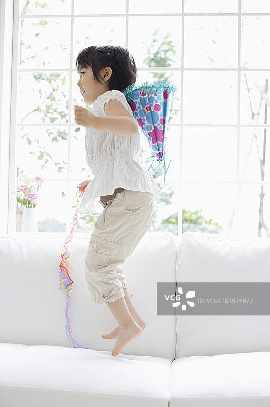 女孩在沙发上跳跃图片素材