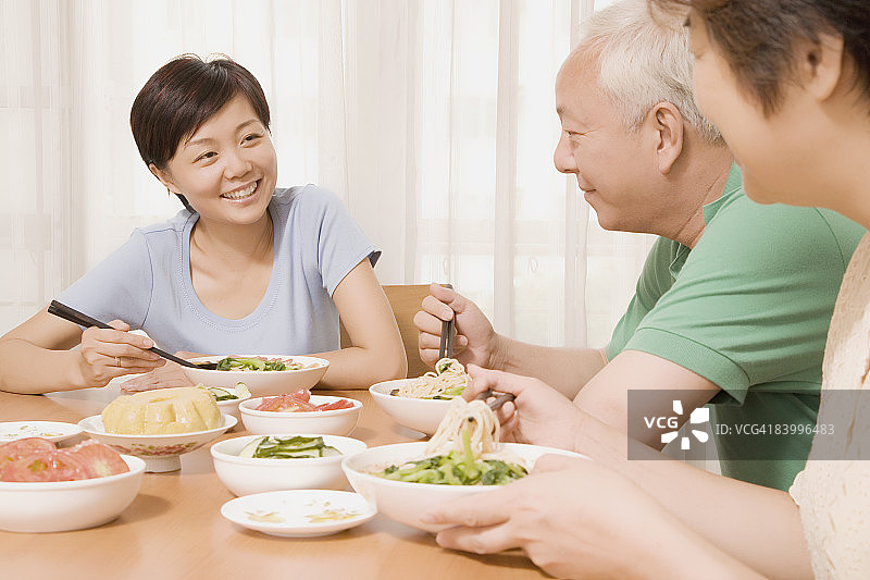 中年女人和父母坐在餐桌旁图片素材