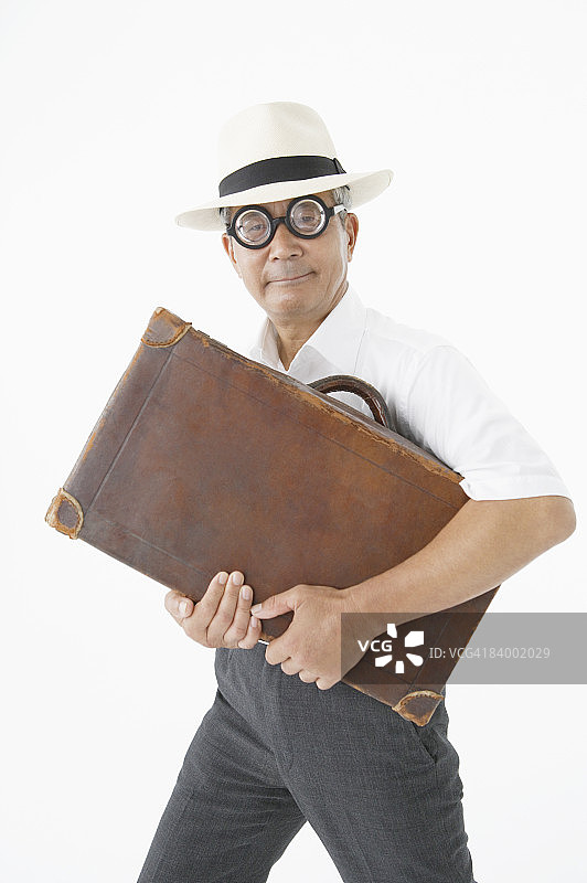 手提箱戴玩具眼镜的老年商人 портрет，工作室拍摄图片素材