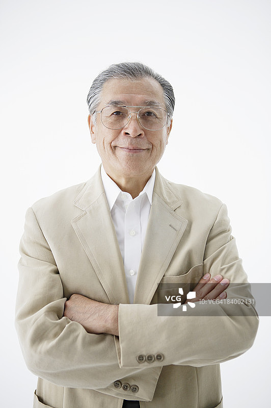 双臂交叉的老年男人特写工作室肖像图片素材
