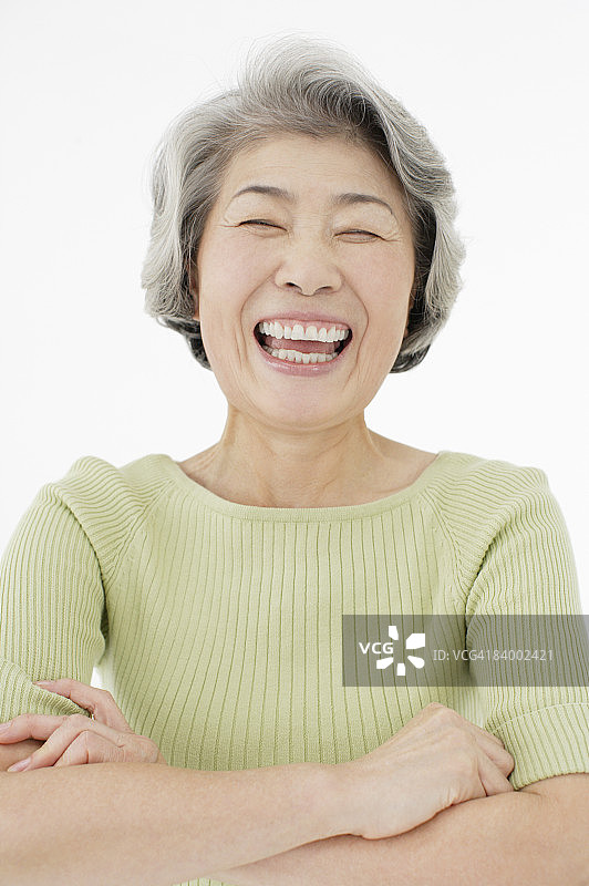 年长妇女双臂交叉的肖像，特写，摄影棚拍摄图片素材