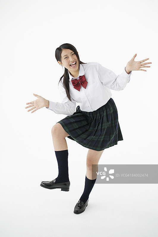 女学生做滑稽的姿势，工作室拍摄图片素材