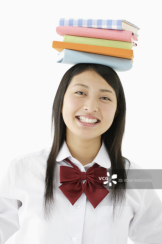 头顶书本的女学生，工作室拍摄图片素材