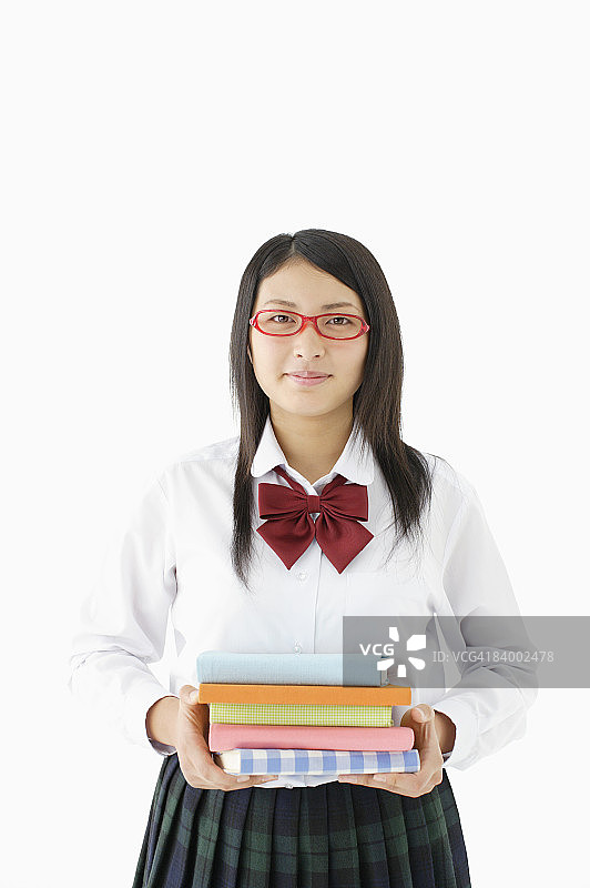 戴眼镜的女学生拿着书的影棚照图片素材