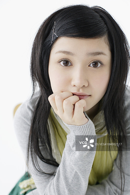 手托下巴的少女特写肖像，工作室拍摄图片素材