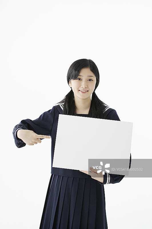女学生拿着白板指点，影棚拍摄图片素材