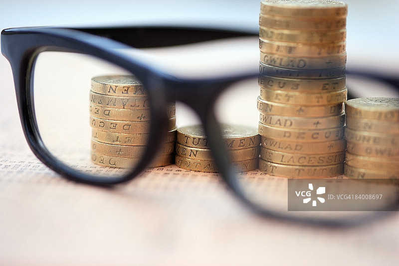 眼镜和英镑硬币在财经报纸上图片素材