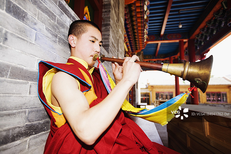 内蒙古呼和浩特大召寺，吹奏号角的年轻男人图片素材