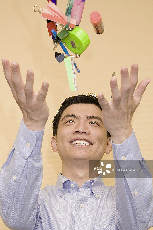 面带微笑抛洒文具的年轻男子特写图片素材