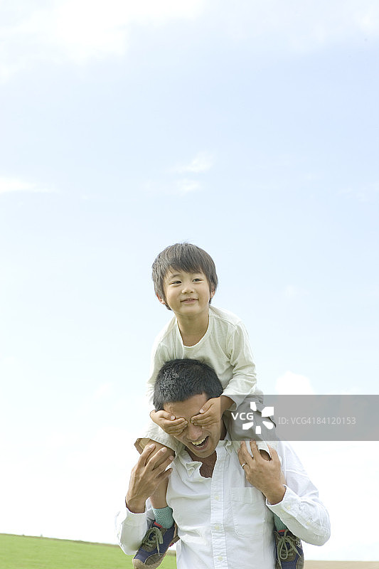 男孩蒙住父亲的眼睛图片素材