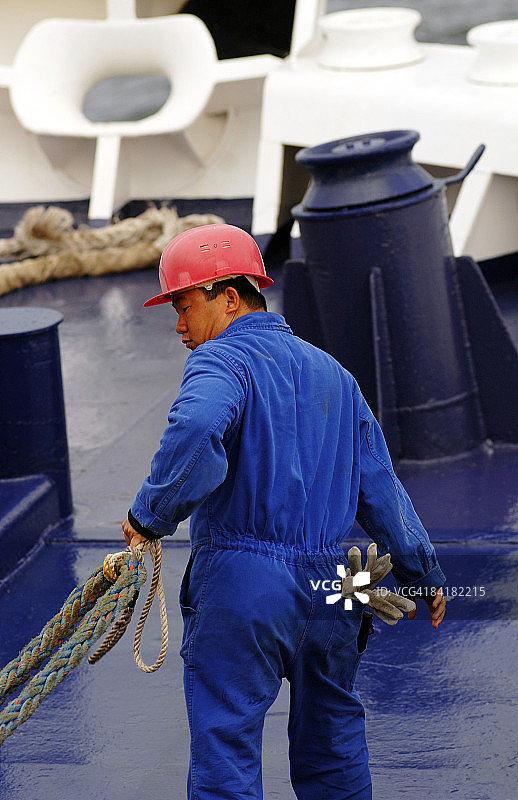 戴安全帽的水手拉着系泊绳图片素材