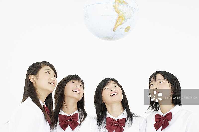 看地球仪的女学生，影棚拍摄图片素材