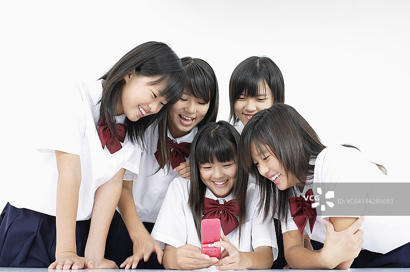 看手机屏幕的女学生（影棚拍摄）图片素材