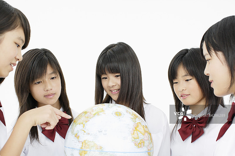 看地球仪的女学生，影棚拍摄图片素材
