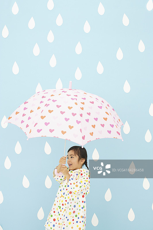穿着雨衣、打着伞的女孩图片素材