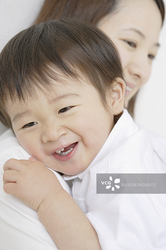 母亲怀抱男婴，焦点在前景图片素材