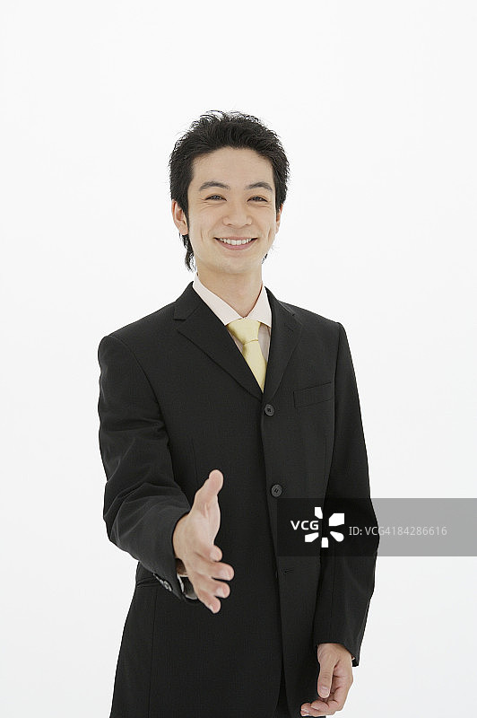 伸出手准备握手的商人，工作室拍摄图片素材
