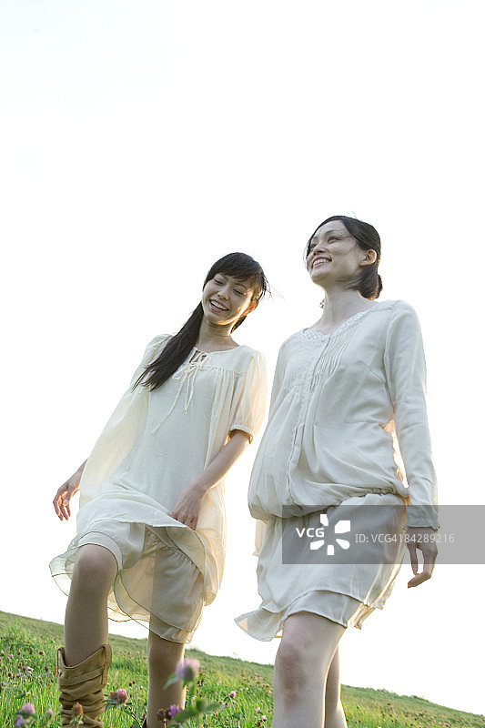 日本女人在草地上微笑同行图片素材