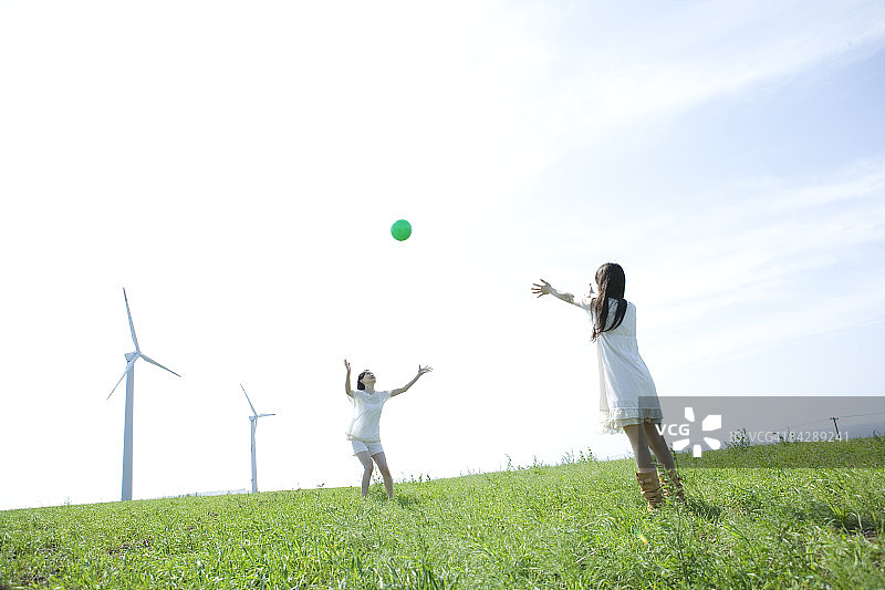 在草地上玩球的日本女子图片素材