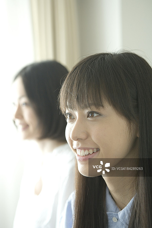 年轻女人微笑并看向远方，肖像图片素材