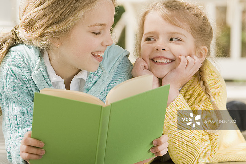 姐妹在门廊上看书图片素材