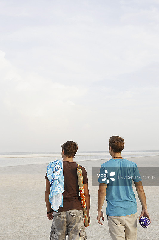 年轻男人在海滩上散步图片素材