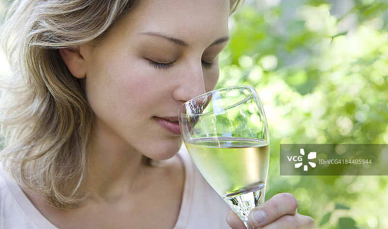 在户外闻白葡萄酒的女人图片素材