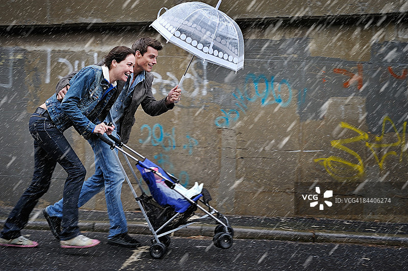 雨中夫妇推着婴儿车图片素材