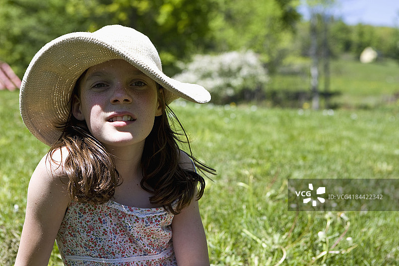 女孩坐在院子里戴着遮阳帽图片素材