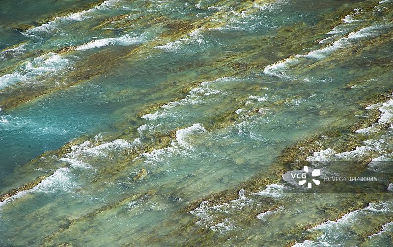 俯瞰岩石上泡沫翻滚的河流图片素材