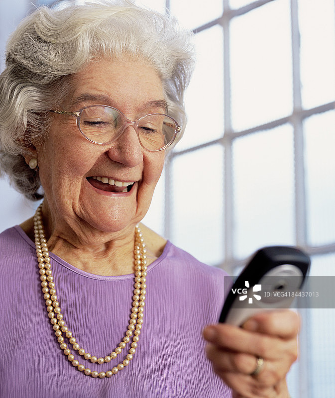 正在查看手机的80岁老妇人图片素材